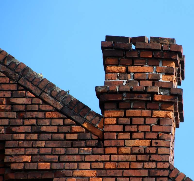 Damaged chimney on an Roosevelt Gardens home showing cracks and missing mortar